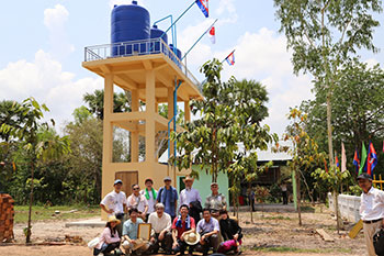第１回「ワールドフード＋ふれ愛フェスタ」（ＷＦＦ）の収益金でカンボジア・シェムリアップ州のポイスマッチ村に簡易水道を建設：簡易水道給水タンク前での記念写真